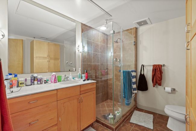 Bathroom featuring vanity, tile patterned flooring, a shower stall, and toilet | Image 9