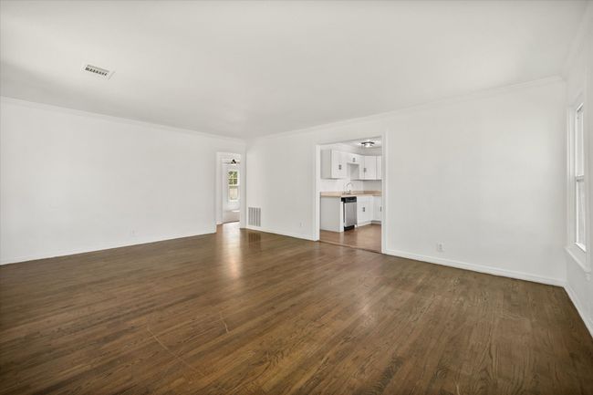 Unfurnished living room with crown molding and dark wood finished floors | Image 22