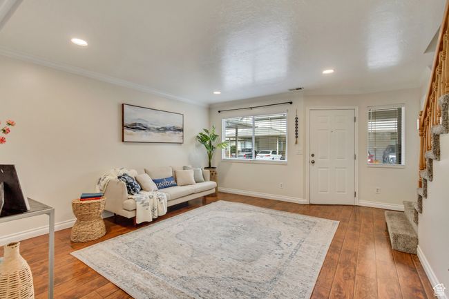 Living room with dark wood finished floors, baseboards, stairway, and ornamental molding | Image 5