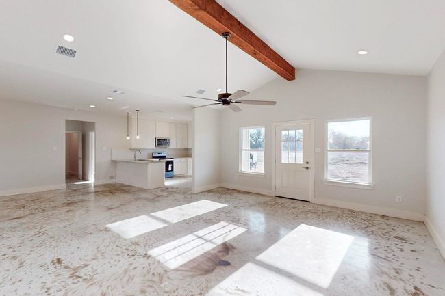 Unfurnished living room featuring lofted ceiling with beams, a ceiling fan, visible vents, recessed lighting, and baseboards | Image 8