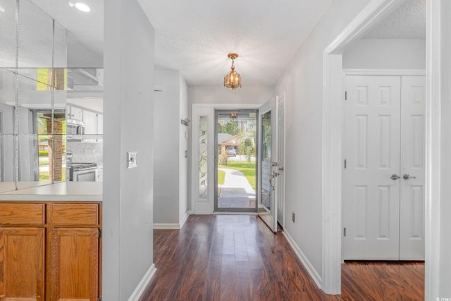 Entryway with baseboards, an inviting chandelier, and dark wood-style flooring | Image 9