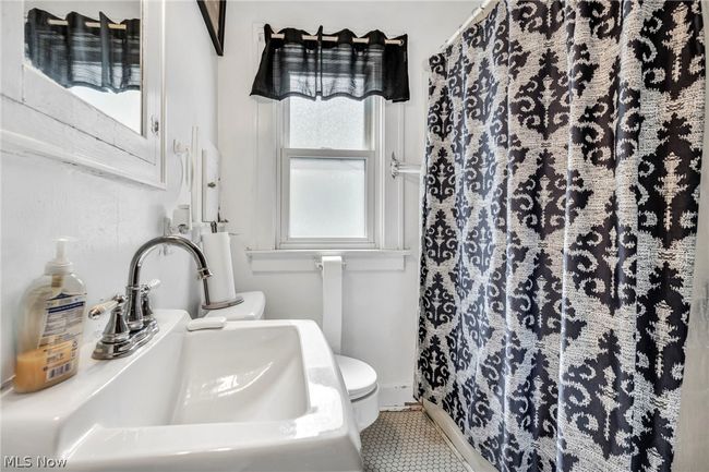 Bathroom with tile floors, sink, and toilet | Image 13