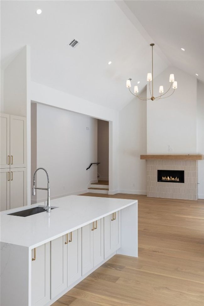 Kitchen with a sink, light wood-style floors, hanging light fixtures, a chandelier, and recessed lighting | Image 10