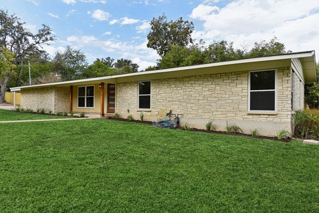 View of front facade featuring stone siding and a front lawn | Image 21