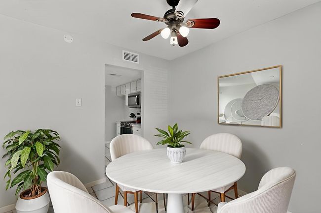 Dining area with ceiling fan and light tile patterned flooring | Image 5