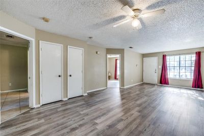 Spare room featuring a textured ceiling, wood-type flooring, and ceiling fan | Image 3