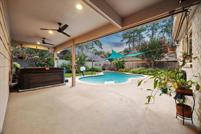 The breezeway also serves as a large, covered patio, spacious enough for entertaining and for the spa/hot tub, while looking out on the poo and surrounding garden. | Image 32