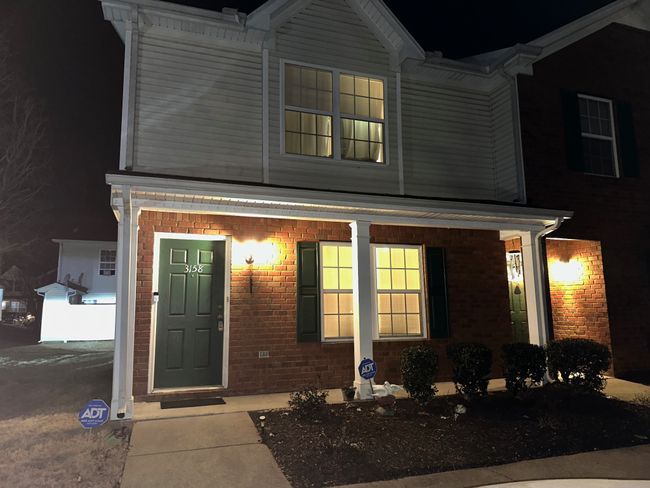 Capturing a photo of this end unit in the evening - showing plenty of outdoor lighting giving you that additional sense of security. HOA includes lawn maintenance and insurance as well as community trash compactor. | Image 44