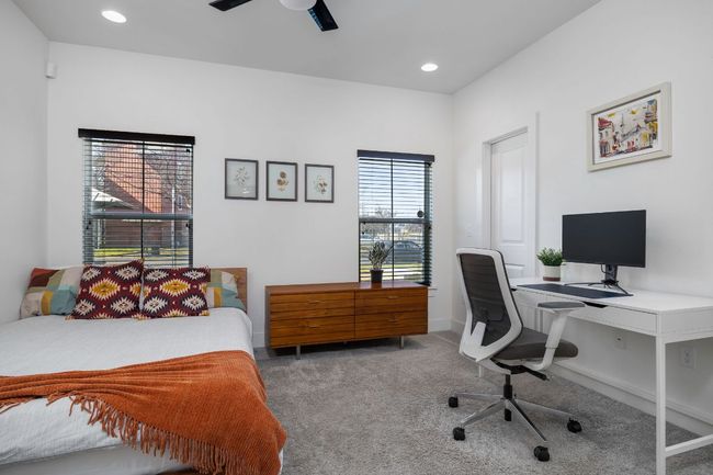 Secondary bedrooms are located on the main level with a shared bathroom. Carpet, a ceiling fan, and recessed lighting. | Image 7