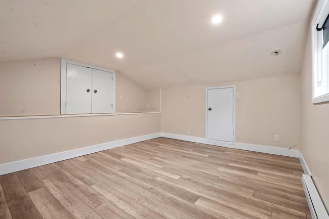 Additional living space featuring a baseboard heating unit, light wood-style floors, baseboards, lofted ceiling, and recessed lighting | Image 19