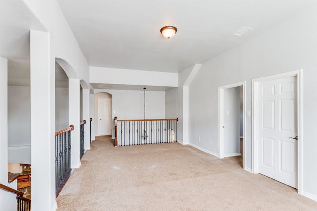 Empty room with light carpet and arched walkways | Image 25