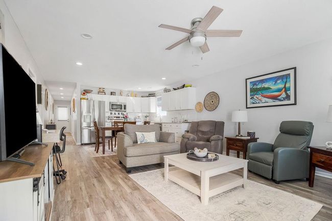 Living room with light wood finished floors, a ceiling fan, and recessed lighting | Image 4