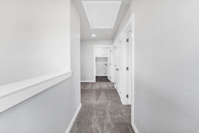 Hallway with attic access, carpet, and baseboards | Image 22