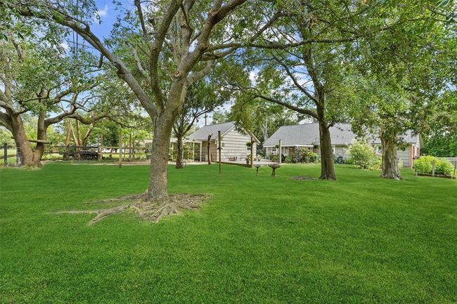 Spacious backyard shaded by mature trees—creating a serene outdoor retreat with plenty of room to relax, entertain, or play. | Image 25