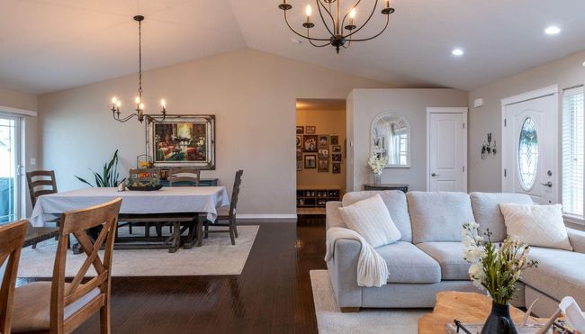 Living area featuring a chandelier, lofted ceiling, dark wood-style flooring, baseboards, and recessed lighting | Image 13
