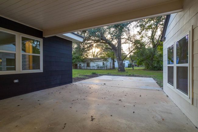 Outside, a spacious covered patio provides plenty of room to create a tranquil outdoor retreat, perfect for relaxation and enjoying the surrounding environment. | Image 36