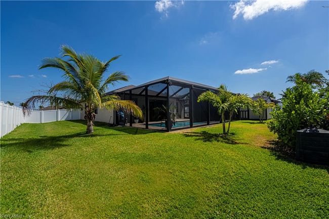 View of yard featuring a fenced backyard, a fenced in pool, central AC, and glass enclosure | Image 32