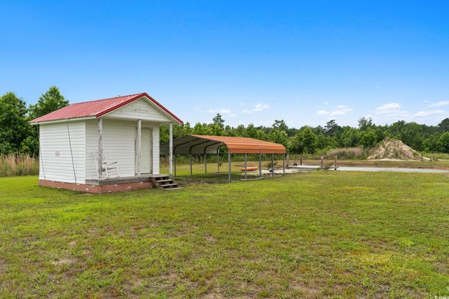 View of green lawn featuring a detached carport | Image 29