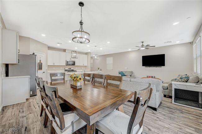 Dining room with light wood-style floors, a ceiling fan, recessed lighting, and a chandelier | Image 18