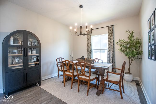 dining room with light wood finished floors and a chandelier | Image 8