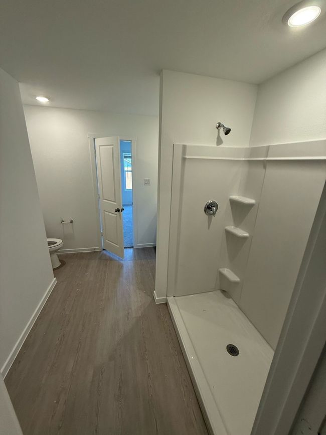 Bathroom featuring wood finished floors, a shower stall, toilet, and baseboards | Image 18