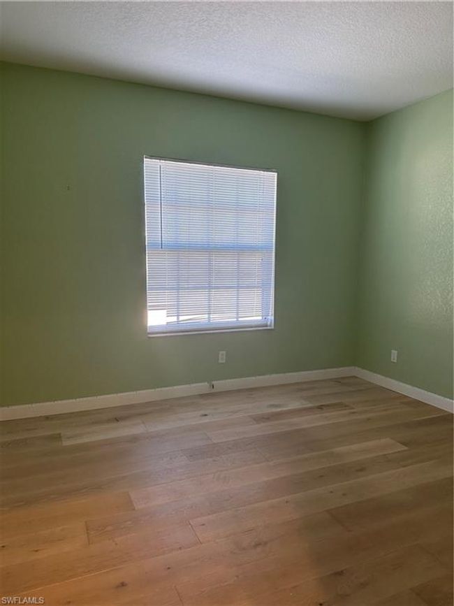 Empty room with light hardwood / wood-style floors and a textured ceiling | Image 4