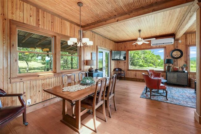 Dining room with a wall mounted AC, beam ceiling, wooden walls, and wood ceiling | Image 10