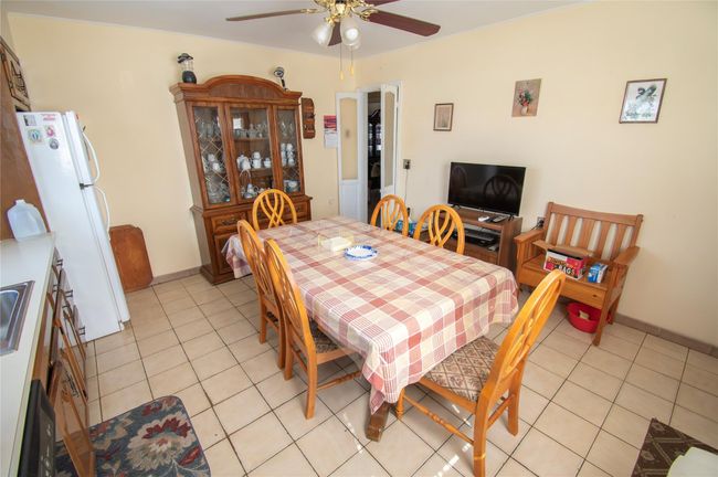 Dining area with light tile patterned floors, baseboards, and a ceiling fan | Image 9