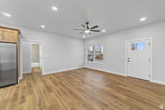 Unfurnished living room with ceiling fan, baseboards, light wood finished floors, and recessed lighting | Image 9