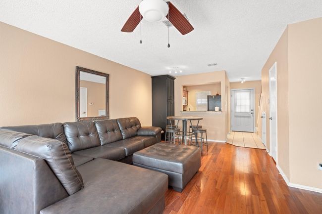 Living area featuring light wood-style floors, ceiling fan, and a textured ceiling | Image 9
