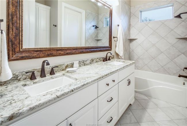 Bathroom featuring a sink, shower / bathtub combination, tile patterned floors, and double vanity | Image 24