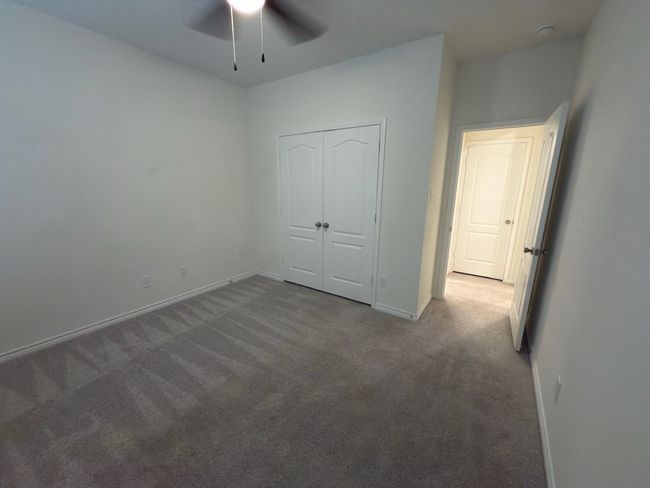 Unfurnished bedroom featuring carpet floors, baseboards, a closet, and ceiling fan | Image 5