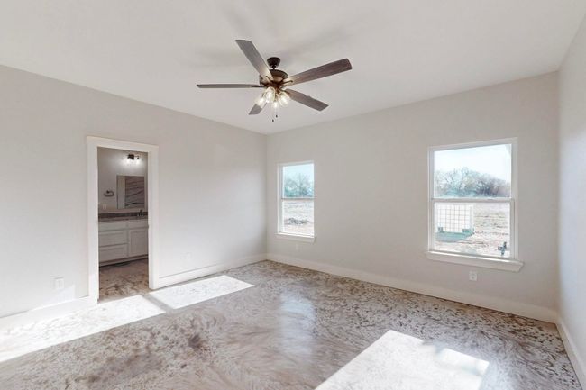 Unfurnished bedroom featuring ensuite bathroom, baseboards, and a ceiling fan | Image 23