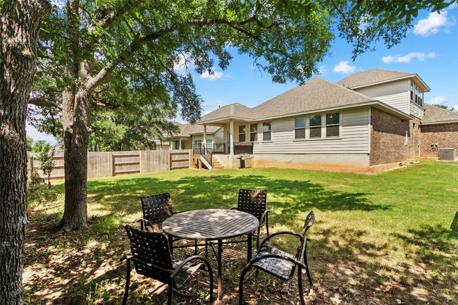 Rear view of property featuring brick siding, stairway, and roof with shingles | Image 31