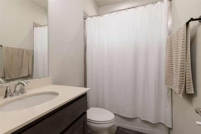 Bathroom featuring toilet, vanity, and shower / tub combo with curtain | Image 12
