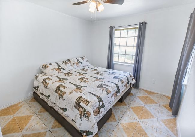 Bedroom featuring ornamental molding, light tile patterned floors, and ceiling fan | Image 12
