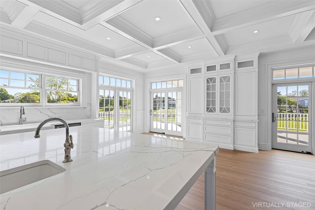 Kitchen with a sink, coffered ceiling, beam ceiling, light wood-style flooring, and white cabinetry | Image 10