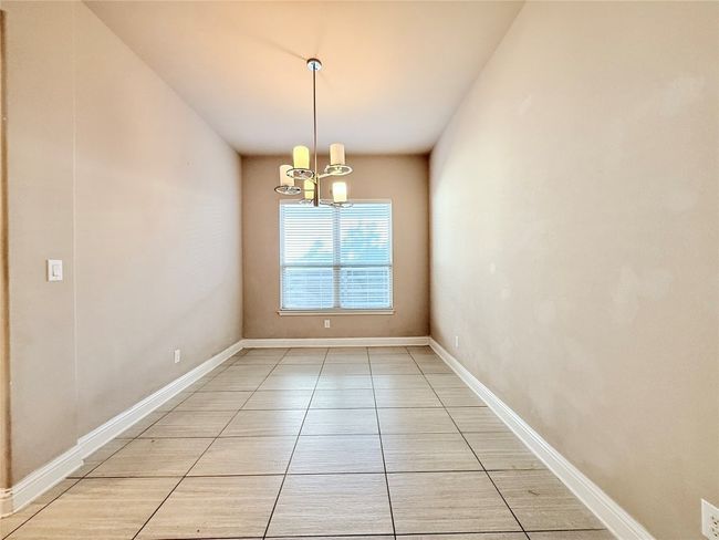 Empty room with a chandelier and light tile patterned floors | Image 22