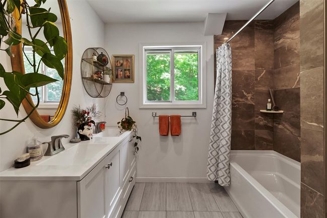 Upstairs Hall bathroom featuring vanity, plenty of natural light, shower / tub combo. | Image 5