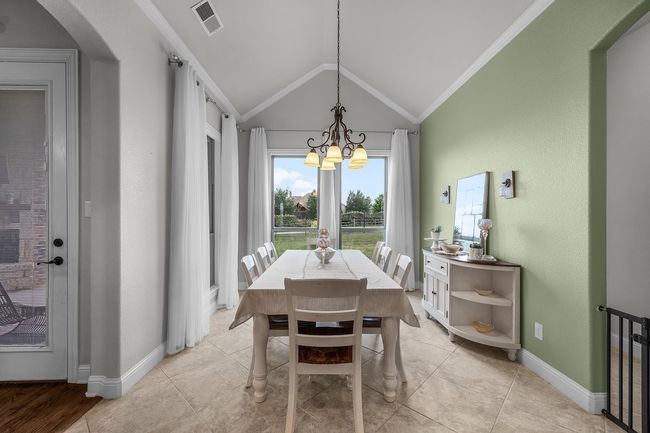 Dining space with a chandelier, vaulted ceiling, arched walkways, baseboards, and ornamental molding | Image 24