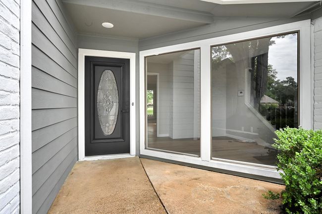 Modern black door and oversized windows bring in natural light. | Image 5