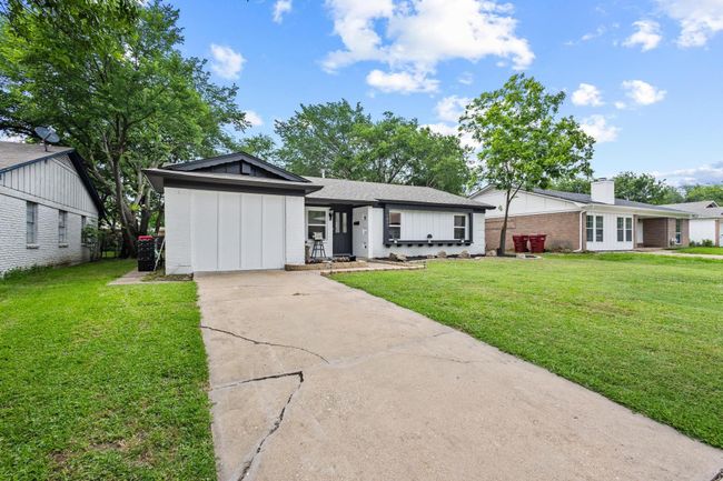Ranch-style home with brick siding, concrete driveway, board and batten siding, and a front lawn | Image 39