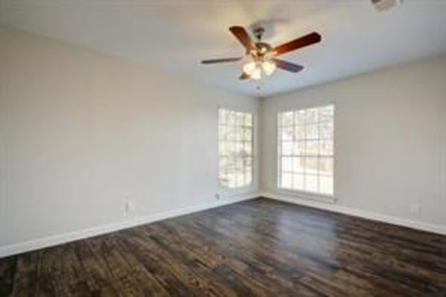 Spare room with ceiling fan, baseboards, and dark wood-type flooring | Image 6