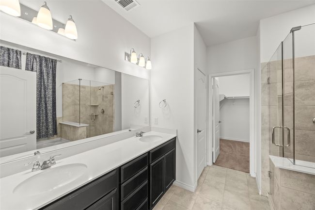 Bathroom with a shower stall, double vanity, a walk in closet, and tile patterned flooring | Image 22