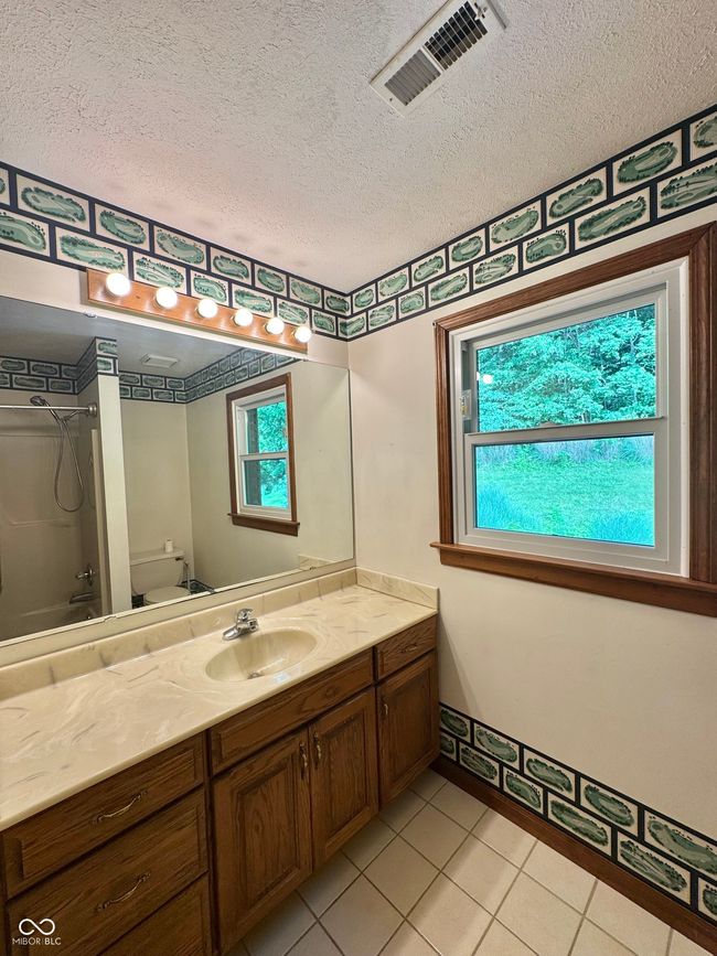 full bathroom with plenty of natural light, toilet, vanity, a textured ceiling, and bathing tub / shower combination | Image 55