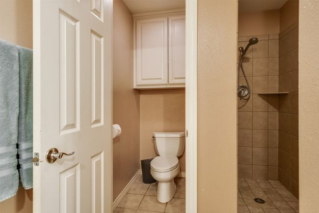 Bathroom with a shower stall, toilet, and tile patterned floors | Image 16