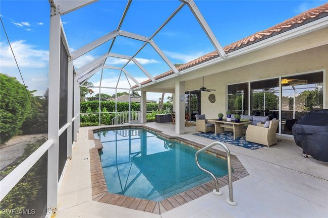 View of swimming pool featuring ceiling fan, a patio, outdoor lounge area, and glass enclosure | Image 22