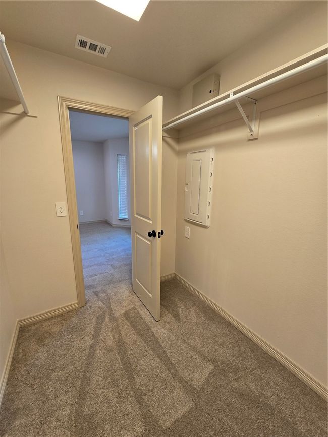 Spacious closet with carpet floors and media panel | Image 13