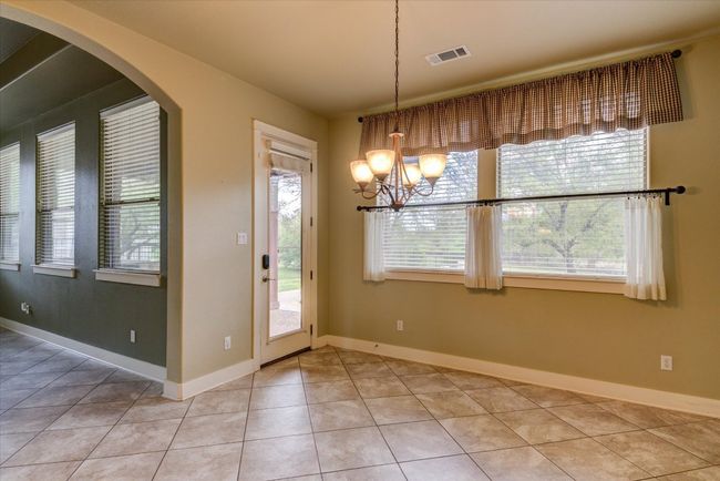 Dining area with a healthy amount of sunlight, a chandelier, and light tile patterned floors | Image 14