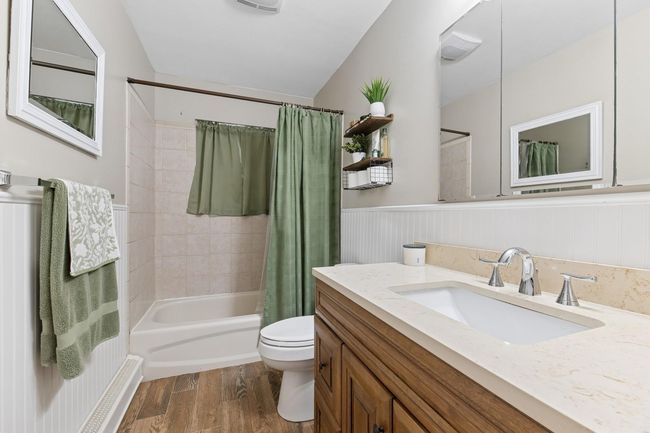 Full bathroom with shower / bath combo, vanity, wood finished floors, and a wainscoted wall | Image 17